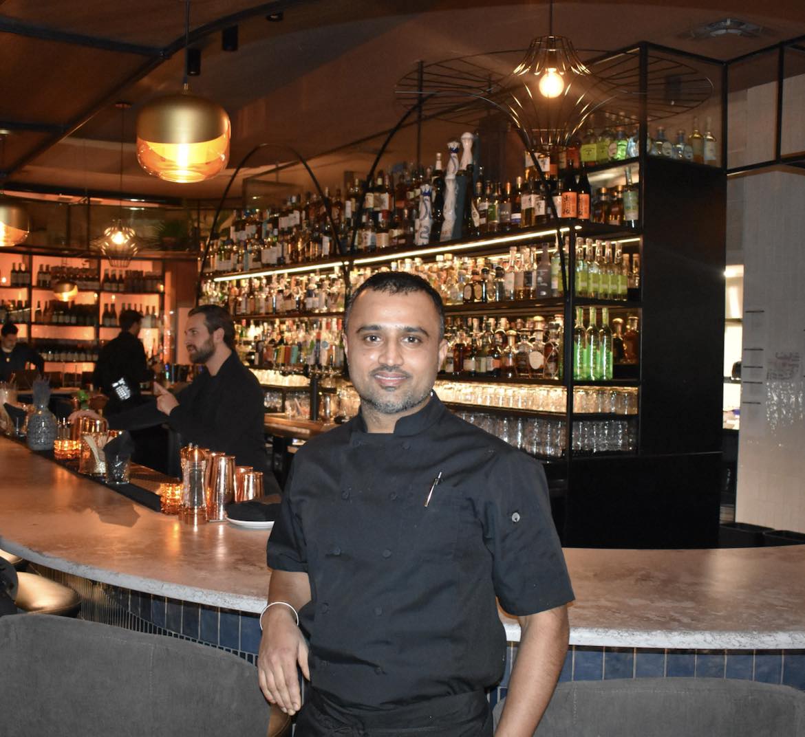 Chef Inderjeet smiling at upscale bar